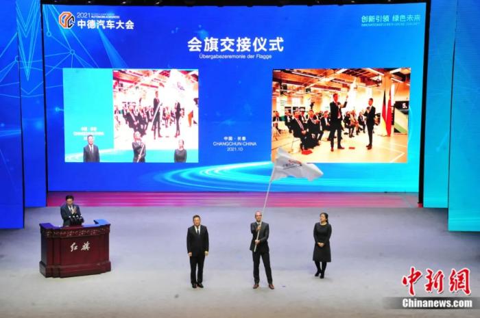 2021年10月19日，2021中德汽車大會在吉林長春舉行。中外汽車領(lǐng)域的專家學(xué)者、知名汽車廠商及汽車零部件企業(yè)代表和政府官員，圍繞“創(chuàng)新引領(lǐng) 綠色未來”主題展開探討。圖為中德汽車大會會旗交接儀式。高龍安 攝
