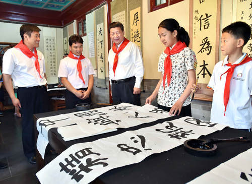 2014年5月30日上午，中共中央總書記、國家主席、中央軍委主席習近平來到北京市海淀區(qū)民族小學，參加慶?！傲弧眹H兒童節(jié)活動。這是習近平觀看學生書寫的毛筆字。新華社記者 李濤 攝