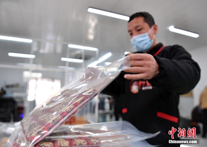 1月18日，雄安新區(qū)大樹劉莊村辛愛青家中的冰糖葫蘆加工廠，工人正對冰糖葫蘆半成品進行真空塑封。作為遠近聞名的“冰糖葫蘆村”，大樹劉莊村制作冰糖葫蘆的歷史已有100多年，全村三分之二的村民都會這門手藝，吸引不少游客慕名而來。 中新社記者 韓冰 攝